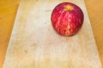 One Apple On The Chopping Block In Kitchen Stock Photo