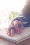 Woman Hand With Pen Writing On Notebook Stock Photo