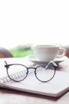 Open Blank White Notebook And Eyeglasses With Cup Of Coffee Stock Photo