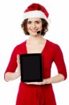 Pretty Female Santa Presenting Touch Pad Stock Photo