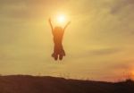 Silhouette Of Woman Jumping Against Beautiful Sky Background Stock Photo