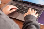 Woman Using Laptop At Office Desk Stock Photo