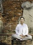 Woman Meditating In Temple Stock Photo