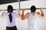 Female And Male Taking Pull Ups Stock Photo