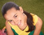 Smiling Cheerleader Sitting On Grass Stock Photo