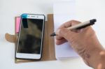 Mobile Phone Notebook And Pen On White Background Stock Photo