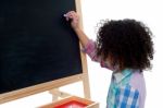 Young School Child Writing On Blackboard Stock Photo