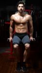 Young Man Doing Heavy Weight Exercise In Gym Stock Photo