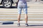 Waiting Young Man At The Pedestrian Crossing And Car Traffic Stock Photo