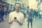 Smiling Man With Cell Phone Walking Stock Photo