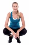 Young Female Trainer In Squat Position Stock Photo