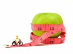 Miniature Woman Riding Bicycle Near Green Apple And Measuring Ta Stock Photo