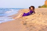 Cute White Girl Laying On Sand At The Beach Stock Photo