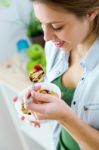 Beautiful Young Woman Eating Cereals In The Kitchen Stock Photo