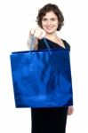 Woman Offering You Bright Blue Shopping Bag Stock Photo