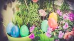 A Few Colorful Easter Eggs At The Green Garden With Colorful Flowers Happy Easter Stock Photo