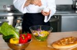 Chef Sprinkling Salt On Vegetables Stock Photo