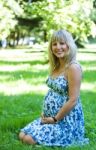 Young Pregnant Woman In City Park Stock Photo