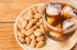 Glass Of Black Iced Coffee With Almond Grain Stock Photo