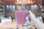 Woman Holding Coffee Mug With Blurred Cafe Background Stock Photo