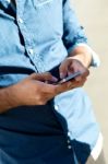 Young Man Using Mobile Phone In The Street Stock Photo