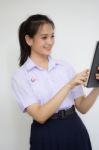 Portrait Of Thai High School Student Uniform Beautiful Girl Using Her Tablet Stock Photo