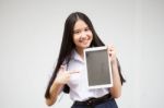 Portrait Of Thai High School Student Uniform Beautiful Girl Using Her Tablet Stock Photo