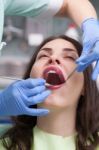 Dentist Curing A Female Patient Stock Photo