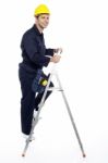 Young Worker Climbing Stepladder Stock Photo