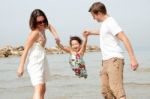 Father And Mother Hold The Daughter Stock Photo