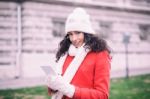 Beautiful Woman In Red Coat And Wool Cap And Gloves With Smartph Stock Photo