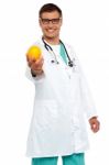 Male Doctor Showing Orange Fruit Stock Photo