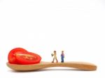 Miniature Children Standing On Fresh Grape Or Cherry Tomato With Stock Photo