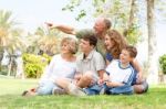 Potrait Of Grandfather Pointing With Family Stock Photo