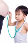 Little Asian Boy Examining Pregnant Mother's Tummy Stock Photo