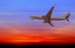 Commercial Airplane Flying At Sunset Stock Photo