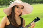 Asian Woman Playing Ukulele Stock Photo