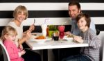 Family Eating Lunch Together In Restaurant Stock Photo