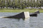 A Wakeskater Slides Across A Huge Floating Rail Obstacle Behind Stock Photo