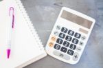 Calculator, Notepad And Pen On Grey Background Stock Photo