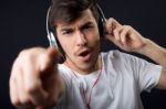 Young Beautiful Man Listening To Music. Isolated On Black Stock Photo