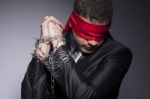 His Hands Are In Chains And His Eyes Are Blindfolded Stock Photo