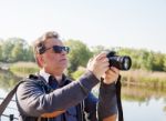 Elderly Man Photographing River Stock Photo