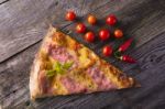 Piece Of Hot Pizza On Wooden Table, Cherry Tomato And Hot Pepper Stock Photo