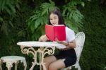 Thai Adult Student University Beautiful Girl Reading Red Book Stock Photo