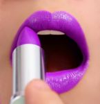 Applying Violet Lipstick Stock Photo