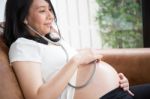 Pregnant Woman Using Stethoscope Stock Photo