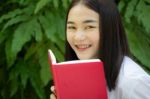 Thai Adult Student University Beautiful Girl Reading Red Book Stock Photo