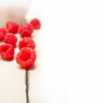 Bunch Of Fresh Raspberry On A Bowl And White Table Stock Photo