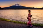 Asian Woman Wearing Japanese Traditional Kimono At Fuji Mountain. Sunset At Kawaguchiko Lake In Japan Stock Photo